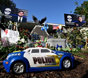 A memorial for El Monte Cpl. Michael Paredes and Officer Joseph Santana is displayed in El Monte, Calif., on Wednesday, June 15, 2022. The pair were killed in a shootout along with the suspect the day before while investigating a possible stabbing in a motel.