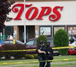 Police secure an area around a supermarket where several people were killed in a shooting, Saturday, May 14, 2022, in Buffalo, N.Y.