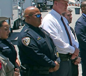 Uvalde School Police Chief Pete Arredondo, second from left, stands during a news conference outside of the Robb Elementary school in Uvalde, Texas, on May 26, 2022. The Uvalde school district’s police chief has stepped down from his position in the City Council just weeks after being sworn in following allegations that he erred in his response to the mass shooting at Robb Elementary School that left 19 students and two teachers dead.