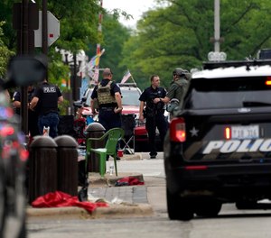 Law enforcement search in downtown Highland Park, a Chicago suburb, after a mass shooting at the Highland Park Fourth of July parade, Monday, July 4, 2022.