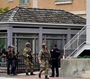 Law enforcement search in downtown Highland Park, Ill., a Chicago suburb, after a mass shooting at the Highland Park Fourth of July parade, Monday, July 4, 2022.