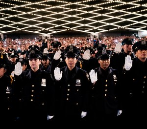 New York City Police Academy graduates raise their right hands as they take their oath during their graduation ceremony at Madison Square Garden, Friday, July 1, 2022, in New York.