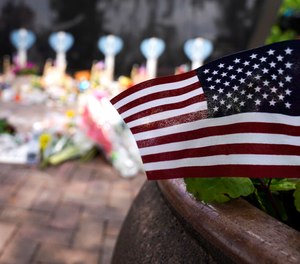 A small American flag is displayed at a memorial to the seven people killed and others injured in Monday's Fourth of July mass shooting at the Highland Park War Memorial in Highland Park, Ill., Thursday, July 7, 2022.