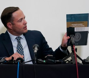 Texas House investigative committee chairman Rep. Dustin Burrows holds a copy of its full report on the shootings at Robb Elementary School as the committee meets, Sunday, July 17, 2022, in Uvalde, Texas.