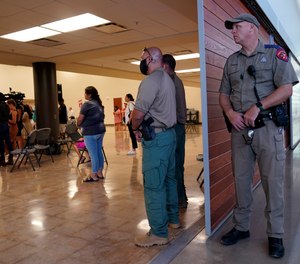 A Texas state trooper and other members of law enforcement listen to the Texas House investigative committee during a news conference after they released a full report on the shootings at Robb Elementary School, Sunday, July 17, 2022, in Uvalde, Texas.