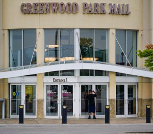 A customer checks a door at the closed Greenwood Park Mall in Greenwood, Ind., Monday. The mall was closed after four people were fatally shot and two were injured, including a 12-year-old girl, after a man with a rifle opened fire in a food court and an armed civilian shot and killed him.