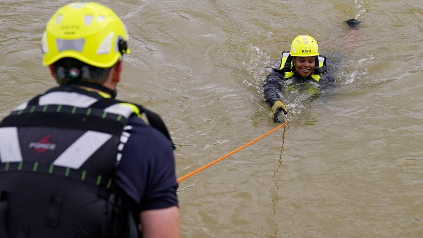 Oklahoma City firefighter Cpl. Evelyn Taylor, right, is pulled to safety by firefighter Lt. Andrew Blagg, left, during swift water rescue training Wednesday, July 20, 2022, in Oklahoma City. 