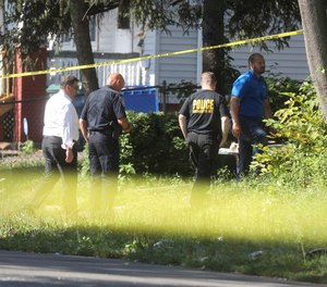 Rochester police investigate behind a house on the corner of Bauman and Laser Streets where two police officers were shot last night in this area in Rochester, N.Y., on Friday, July 22, 2022.
