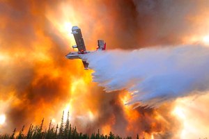 A plane dropped water on the Clear Fire near Anderson, Alaska, on July 6. Alaska's remarkable wildfire season includes over 530 blazes that have burned an area more than three times the size of Rhode Island, with nearly all the impacts, including dangerous breathing conditions from smoke, attributed to fires started by lightning.