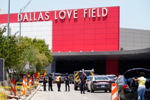 Emergency responders converge near the main entrance of Dallas Love Field Airport on Monday. A 37-year-old woman fired several gunshots, apparently at the ceiling, inside the airport before an officer shot and wounded her, authorities said.