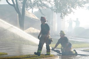 Firefighters work on putting out hot spots after several homes burned in Balch Springs, Texas, on Monday.