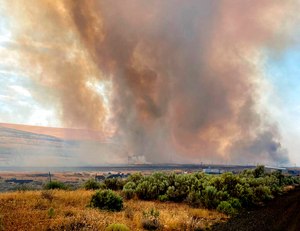 Smoke extends from a wildfire burning south of Lind, Washington on Thursday, Aug. 4, where the fast-moving fire burned half a dozen homes.