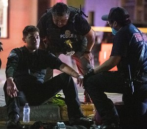Police officer Ramon Perez is treated for shock after an SUV drove through the parade route.