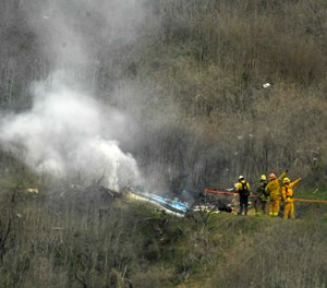 Firefighters work the scene of a helicopter crash where former NBA basketball star Kobe Bryant died in Calabasas, Calif., Jan. 26, 2020.