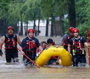 Members of the Balch Springs Fire Department bring a family of four by boat to higher ground after rescuing them from their home along Forest Glen Lane in Balch Springs, Texas, Monday, Aug. 22, 2022.
