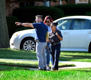 Detroit Police and investigators look over a shooting scene in Detroit.