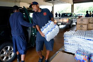 A Jackson, Miss., firefighter puts cases of bottled water in a resident's SUV on Aug. 18 as part of the city's response to longtime water system problems.