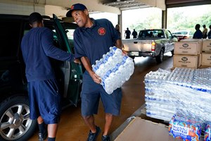 A Jackson, Miss., firefighter puts cases of bottled water in a resident's SUV on Aug. 18 as part of the city's response to longtime water system problems.