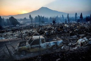 The sun rises over Mt. Shasta and homes destroyed by the Mill Fire on Saturday in Weed, Calif.