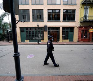 A police officer walks down a nearly deserted Bourbon Street during Mardi Gras in the French Quarter of New Orleans.