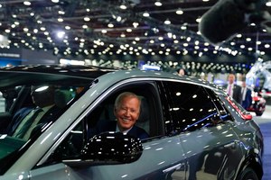 President Joe Biden smiles as he test drives an electric Cadillac Lyriq through the show room at the Detroit Auto Show Wednesday. While at the auto show, Biden said the pandemic is over but a COVID-19 problem continues.