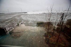 Water from the Bering Sea, pushed by high winds, rushes into a home's backyard in Nome, Alaska, on Saturday. In several Alaska communities, homes were knocked off their foundations or flooded.