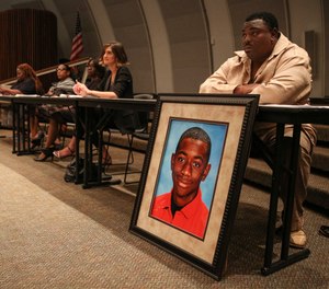 Andrew Joseph Jr. sits behind a picture of his deceased son, Andrew Joseph III.