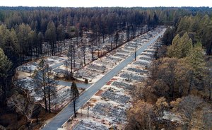 Charred footprints of homes leveled by the Camp Fire line the streets at the Ridgewood Mobile Home Park retirement community in Paradise, Calif., Dec. 3, 2018. Former executives and directors of Pacific Gas & Electric have agreed to pay $117 million to settle a lawsuit over devastating 2017 and 2018 California wildfires sparked by the utility's equipment, it was announced Thursday.
