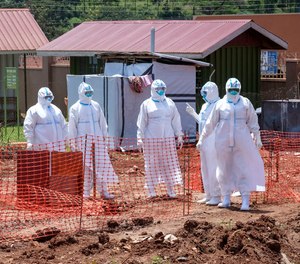 Doctors walk inside the Ebola isolation section of Mubende Regional Referral Hospital, in Mubende, Uganda on Sept. 29, 2022.