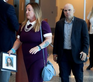 Lori Alhadeff, holding a photo of her daughter Alyssa, and her husband Ilan Alhadeff walk into court during the sentencing hearing for Marjory Stoneman Douglas High School shooter Nikolas Cruz at the Broward County Courthouse in Fort Lauderdale, Fla., on Wednesday, Nov. 2, 2022.