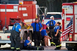 Members of the Waynesville Fire and Rescue Department take a break from battling large fire that burned inside a chemical plant on the coast of Georgia, Monday, Nov. 7, 2022, in Brunswick, Ga.
