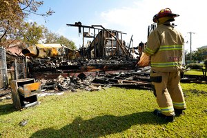 A firefighter observes the remnants of the burned Epiphany Lutheran Church near midtown Jackson, Miss., on Tuesday. Authorities are on the hunt for a suspected arsonist.