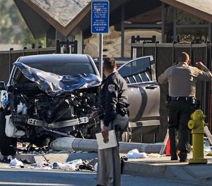 Two investigators stand next to a mangled SUV that struck Los Angeles County sheriff's recruits in Whittier, Calif., Wednesday, Nov. 16, 2022.
