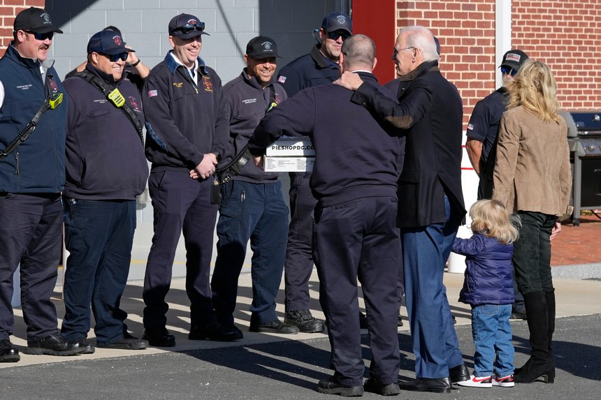 President Joe Biden, with his arm on the shoulder of Nantucket Fire Department Chief Michael Cranson, first lady Jill Biden, right, and their grandson Beau Biden, visit with firefighters on Thanksgiving Day at the Nantucket Fire Department in Nantucket, Mass.