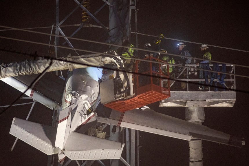 First responders work to rescue aircraft passengers after the small plane crashed and became stuck in live power lines, Monday, Nov. 28, 2022, in Montgomery Village, a northern suburb of Gaithersburg, Md. Both occupants were successfully rescued.