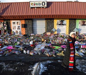 Rev. Paula Stecker of the Christ the King Lutheran Church stands in front of a memorial set up outside Club Q following the mass shooting at the gay nightclub in Colorado Springs, Colo., Tuesday, Nov. 29, 2022.
