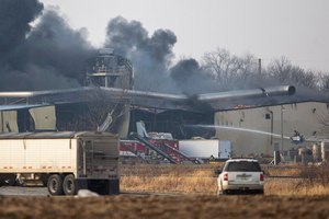 Firefighters work to control a blaze at an agricultural plant Thursday in eastern Iowa. Dozens of people were inside when an explosion happened.