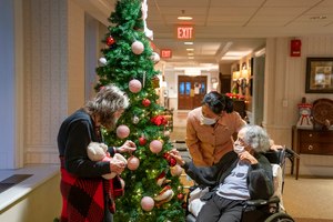 Tina Sandri, CEO of Forest Hills of DC senior living facility (center), greets residents Cherie Neville (left), and Catherine Doleman on Thursday. As nursing home leaders redouble efforts to get staff and residents boosted with the new vaccine version, now recommended for those 6 months and older, they face complacency, misinformation and COVID-19 fatigue.