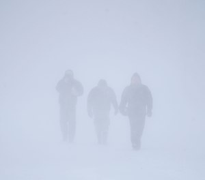 Three men walk down Richmond Avenue in whiteout conditions during a sustained blizzard in Buffalo, N.Y. on Saturday, Dec. 24, 2022.