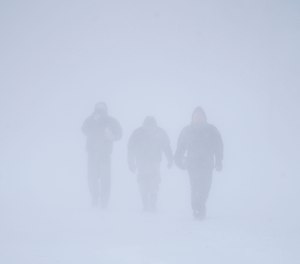 Three men walk down Richmond Avenue in whiteout conditions during a sustained blizzard in Buffalo, N.Y. on Saturday, Dec. 24, 2022.