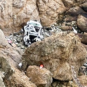 This image from video provided by San Mateo County Sheriff's Office shows a Tesla vehicle that plunged off a Northern California cliff along the Pacific Coast Highway on Monday near an area known as Devil's Slide, leaving four people in critical condition.