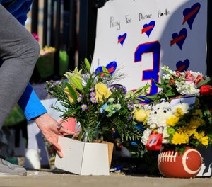 A person leaves flowers for the display set-up for Buffalo Bills' Damar Hamlin outside of University of Cincinnati Medical Center, Wednesday, Jan. 4, 2023, in Cincinnati.