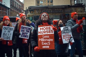 Nurses shout slogans and hold signs during a strike outside Mount Sinai Hospital on Tuesday in New York. Two New York City hospitals have reached a tentative contract agreement with thousands of striking nurses that ends the walkout, the nurses' union announced Thursday.