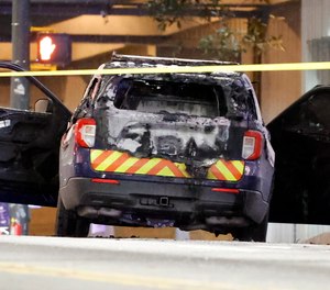 A burned police car sits on the street following a violent protest, Saturday, Jan. 21, 2023.