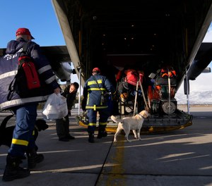 Greek firefighters with dogs board a military plane at Elefsina Air Force Base, in western Athens, Greece, Monday, Feb. 6, 2023.