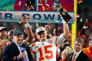 Kansas City Chiefs quarterback Patrick Mahomes (15) holds the Vince Lombardi Trophy next to Terry Bradshaw (left) and Chiefs owner Clark Hunt after the NFL Super Bowl 57 football game against the Philadelphia Eagles on Sunday in Glendale, Ariz. The Kansas City Chiefs defeated the Philadelphia Eagles 38-35. A victory parade back home is planned for Wednesday.