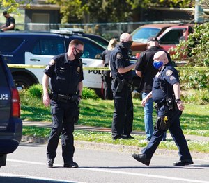 Law enforcement personnel work at the scene following a police-involved shooting of a man in Portland, Ore., on April 16, 2021. An Oregon lawmaker has introduced a bill that would require law enforcement officers complete at least two years of postsecondary education. The bill would push back against the recent trend of lowering police hiring standards by requiring two years of postsecondary education for departments with less than 50 officers and a bachelor's degree for departments with more than 50.