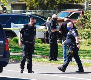 Law enforcement personnel work at the scene following a police-involved shooting of a man in Portland, Ore., on April 16, 2021. An Oregon lawmaker has introduced a bill that would require law enforcement officers complete at least two years of postsecondary education. The bill would push back against the recent trend of lowering police hiring standards by requiring two years of postsecondary education for departments with less than 50 officers and a bachelor's degree for departments with more than 50.