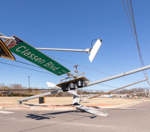 Power lines and street signals lay on the ground along Classen Blvd. at Highway 9 on Monday, Feb. 27, 2023 in Norman, Okla.