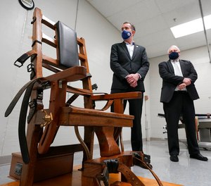 Virginia Gov. Ralph Northam, left, looks over the electric chair in the death chamber at Greensville Correctional Center in Jarratt, Va.